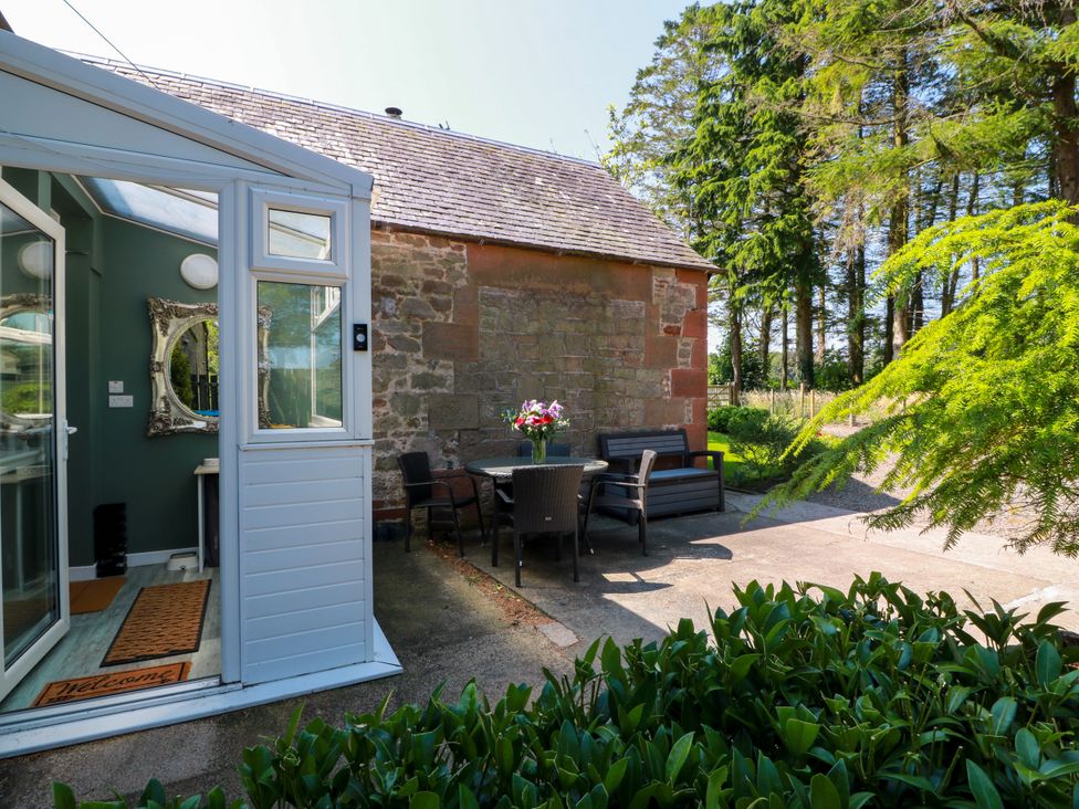 An outdoor area with a table and chairs at Waterside Lodge in Annan
