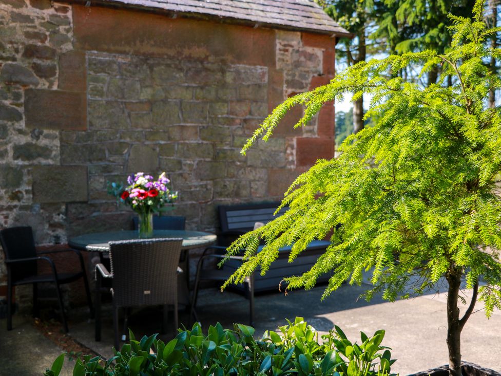 An outdoor seating area with a table and chairs at Waterside Lodge Annan