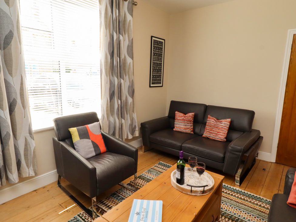 A living room with a sofa and armchair at Farnecrest in Seahouses