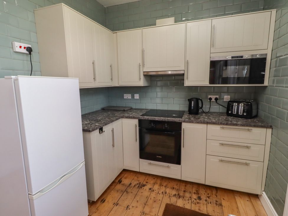 A kitchen with cabinets and appliances at Farnecrest in Seahouses