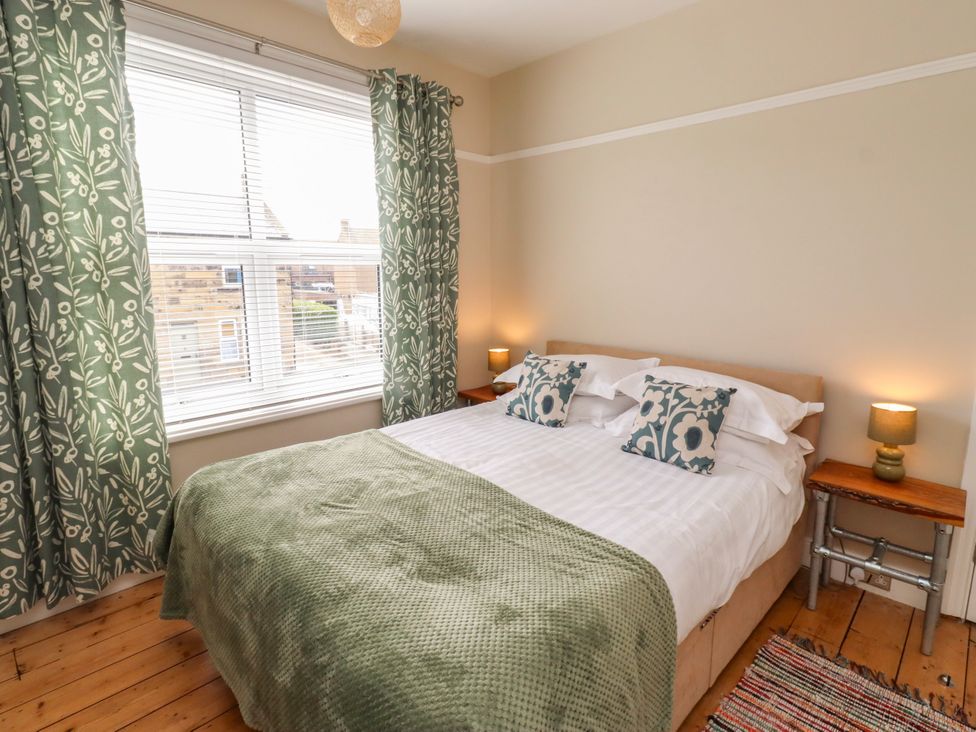 A bedroom with a bed and bedside tables at Farnecrest in Seahouses
