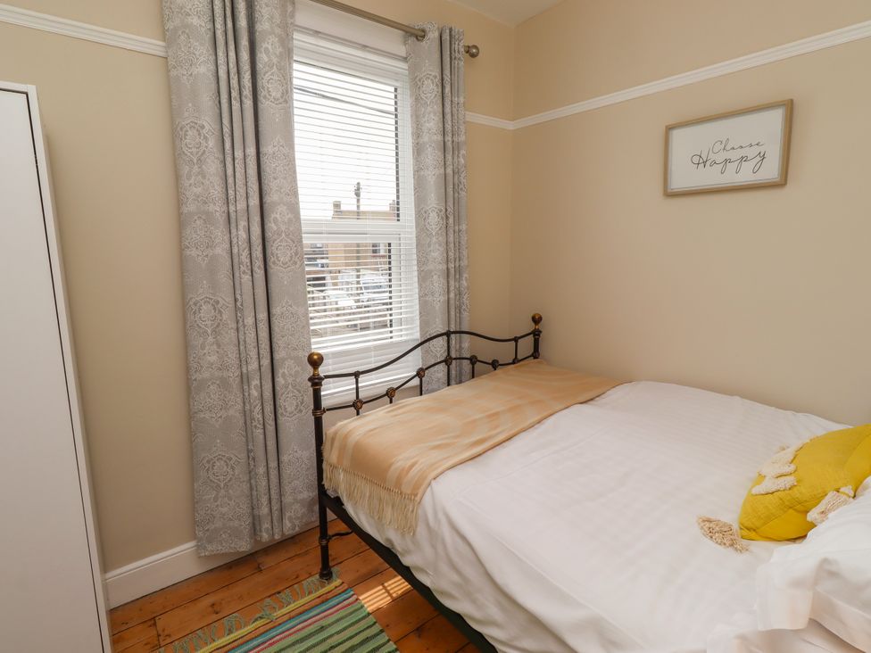A bedroom with a bed and window at Farnecrest in Seahouses