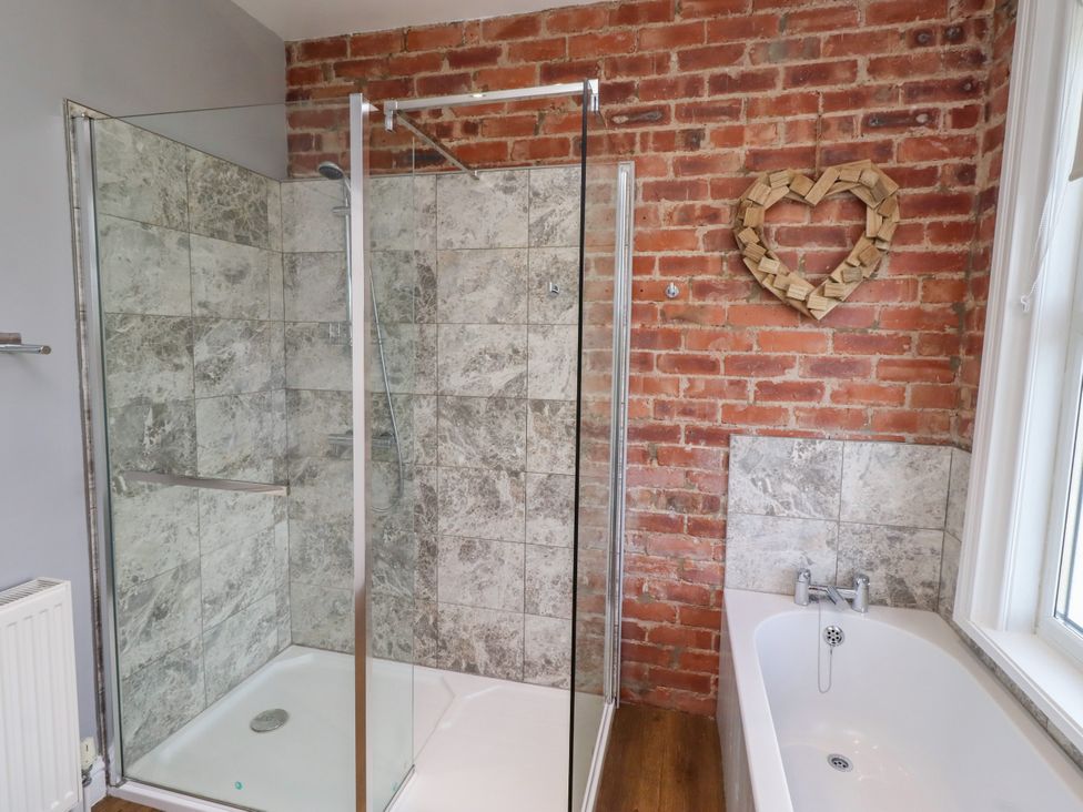 A bathroom with a shower and bathtub at Farnecrest Seahouses