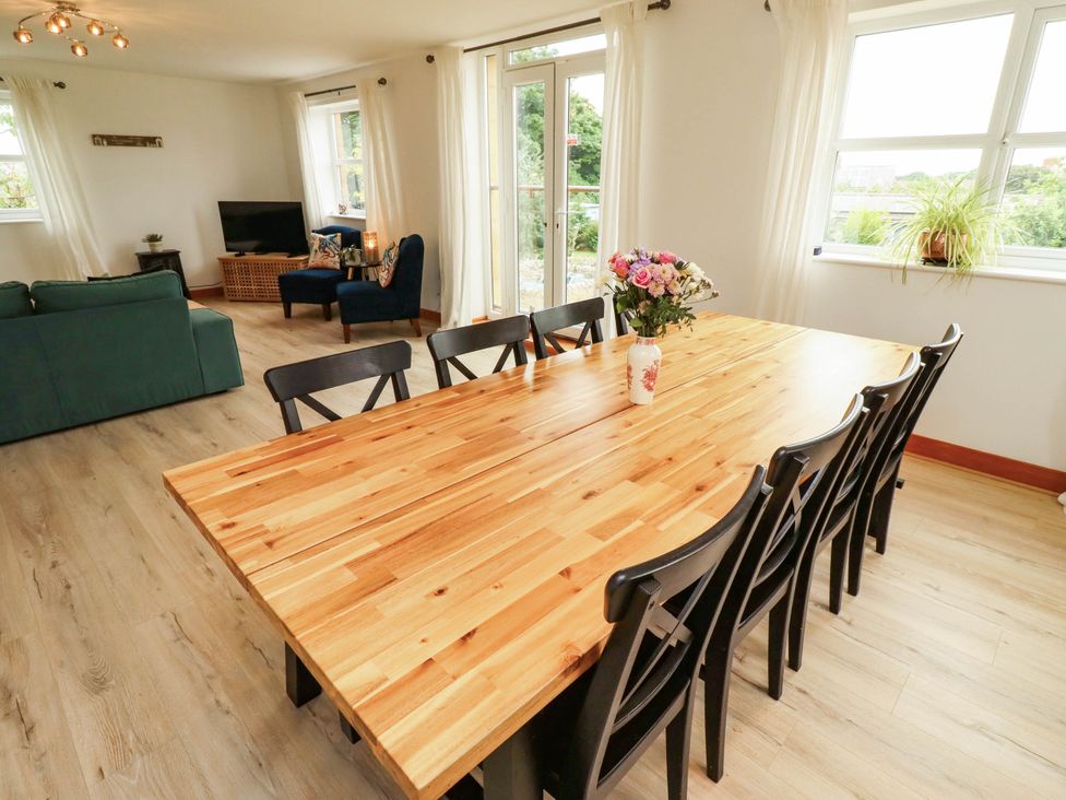 A dining room with a wooden table and chairs at Alma House in Seahouses
