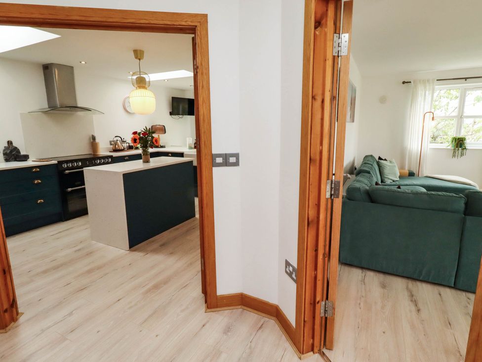 A kitchen with an island and sofa at Alma House in Seahouses