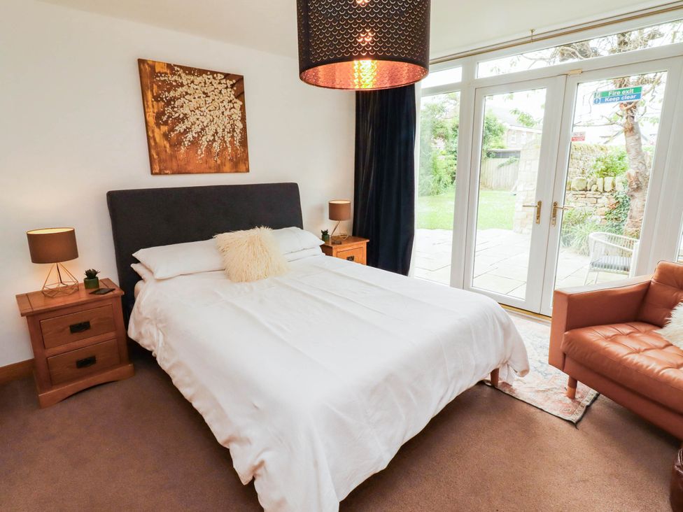 A bedroom with a bed and nightstands at Alma House in Seahouses