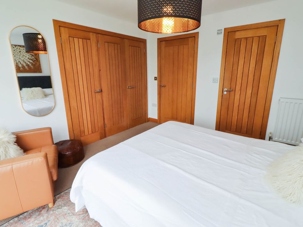 A bedroom with a bed and wardrobe at Alma House in Seahouses
