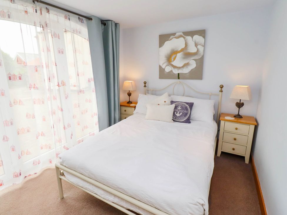 A bedroom with a bed and bedside tables at Alma House in Seahouses