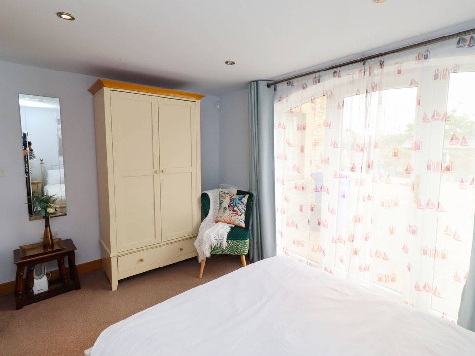 A bedroom with furniture and window at Alma House in Seahouses