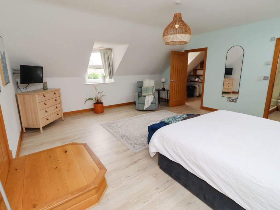 A bedroom with a bed and dresser at Alma House in Seahouses