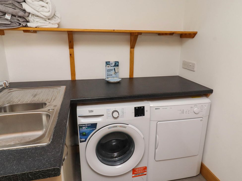 A laundry room with washing machine and tumble dryer at Alma House Seahouses