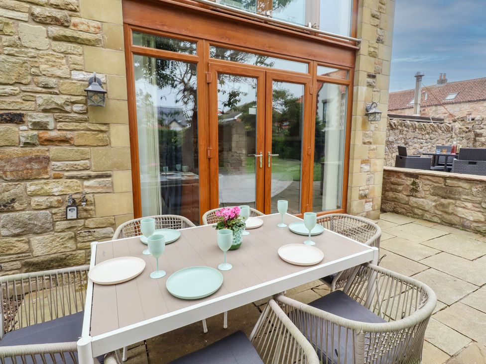 An outdoor dining area with a table and chairs at Alma House in Seahouses