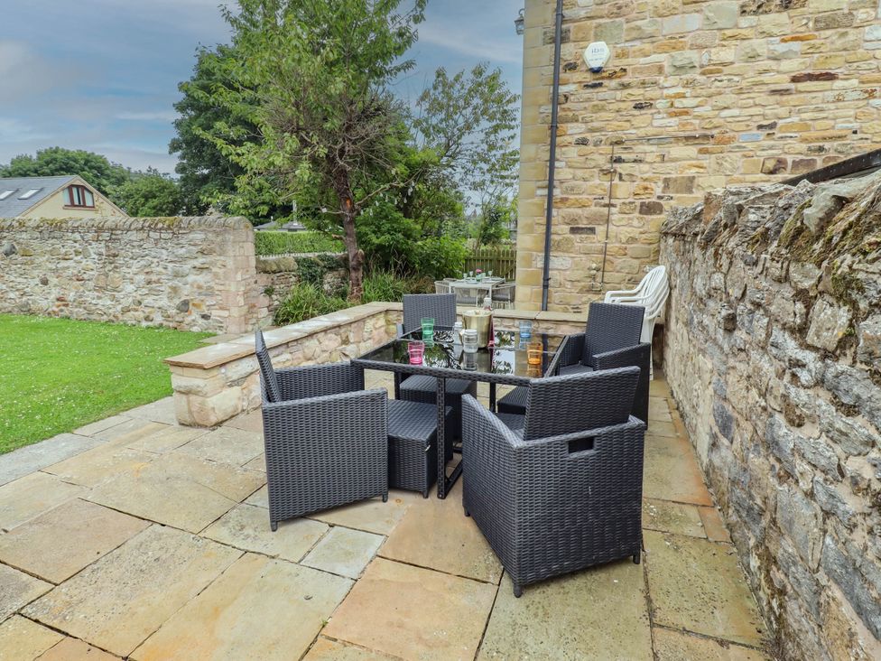 An outdoor patio area with a table and chairs at Alma House in Seahouses