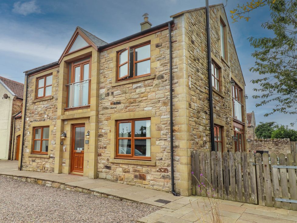 A house with multiple windows and a fenced area at Alma House Seahouses
