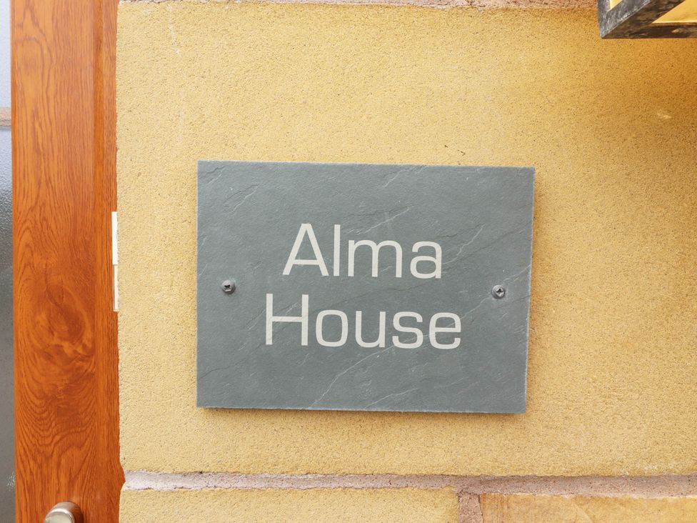 A name plate on a wall for Alma House in Seahouses