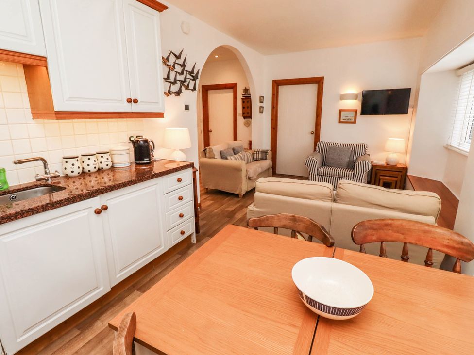 A kitchen with a dining table and living area at Spinnaker