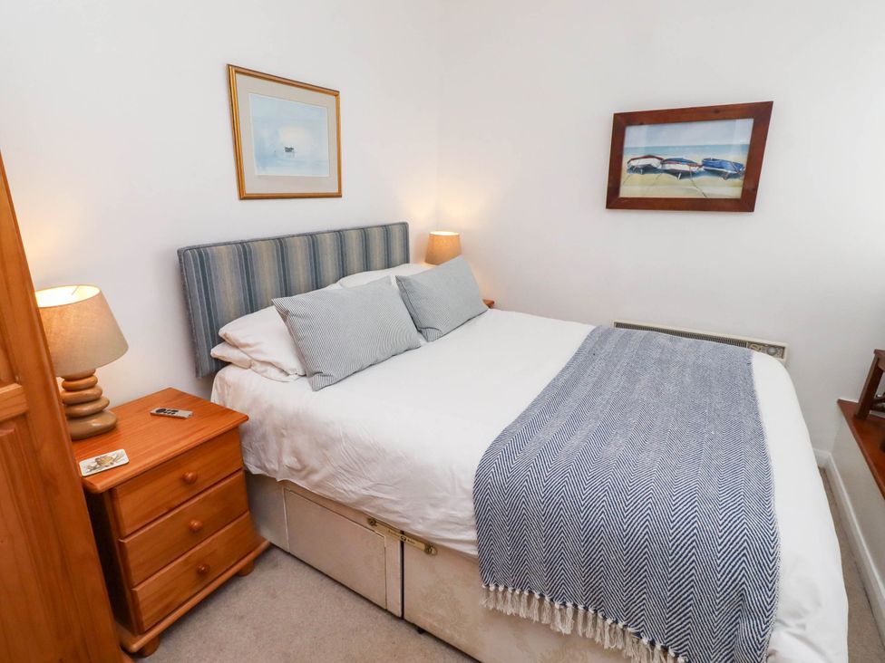A bedroom with a bed and bedside table at Spinnaker