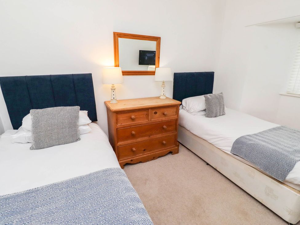 A bedroom with two beds and a dresser at Spinnaker
