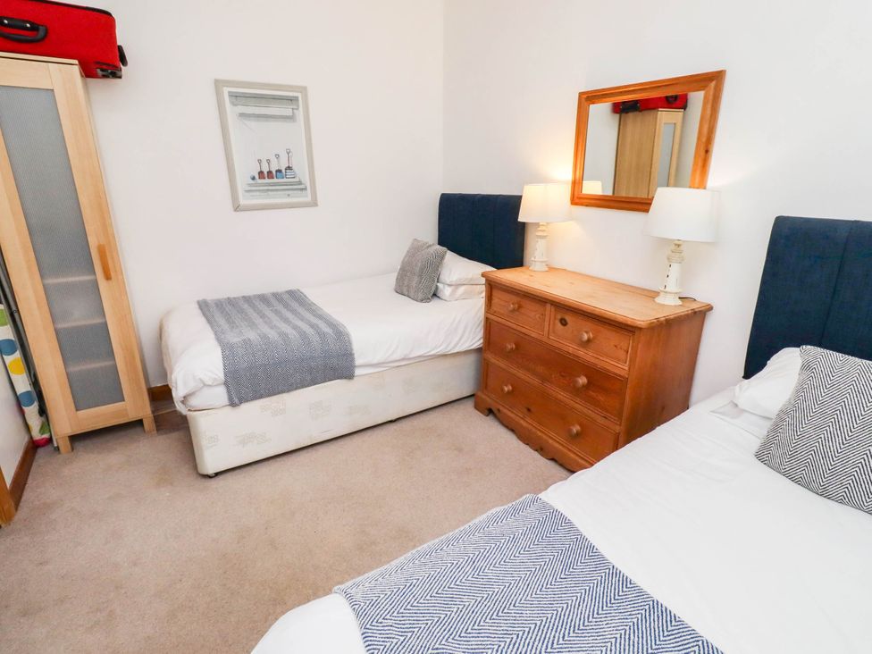 A bedroom with two beds and a dresser at Spinnaker