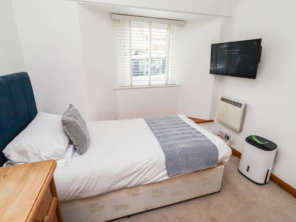 A bedroom with a bed and a television at Spinnaker 