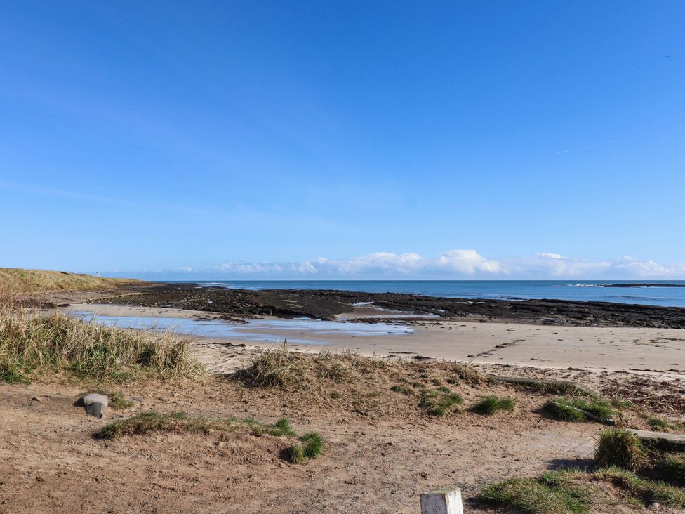 A beach with sand and rocks near the ocean at Spinnaker