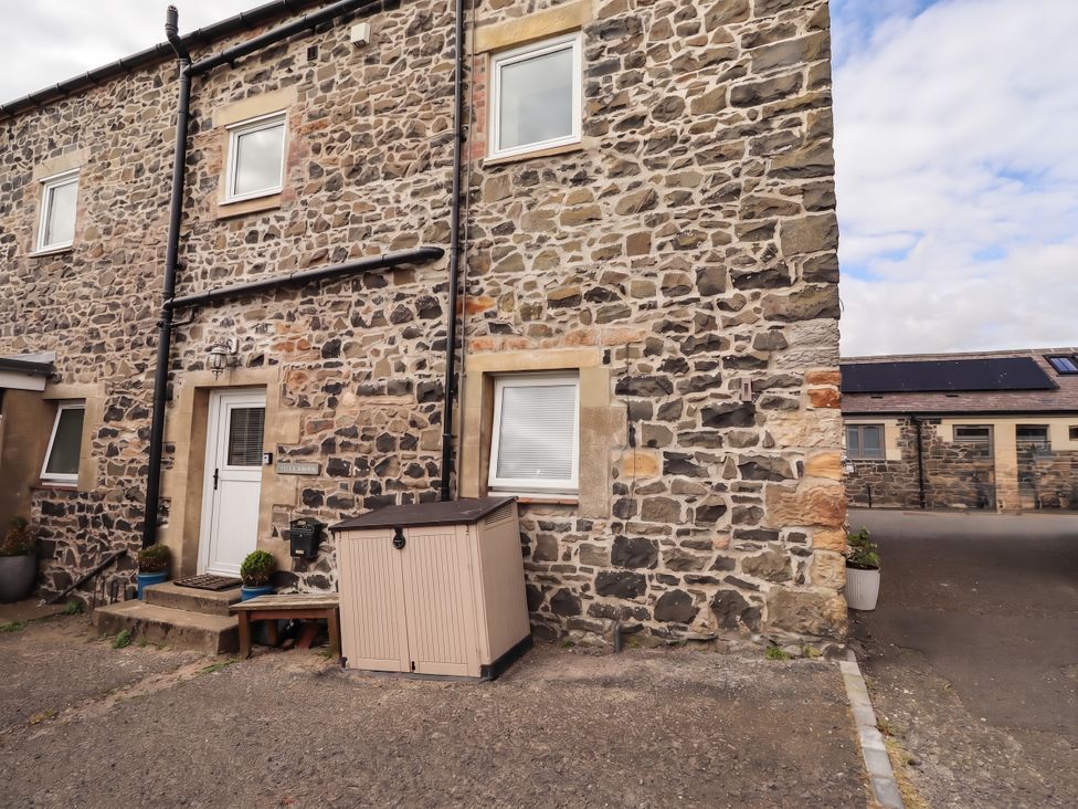 An outdoor area with a stone wall and storage shed at Spinnaker