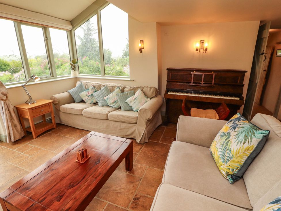 A living room with a sofa and piano at Claybottom Farm near Hesket Newmarket