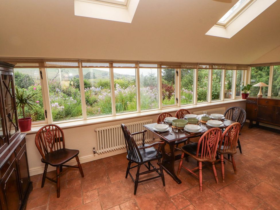 A conservatory with a dining table and chairs at Claybottom Farm near Hesket Newmarket