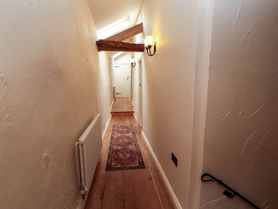A hallway with a rug and light fixture at Claybottom Farm near Hesket Newmarket