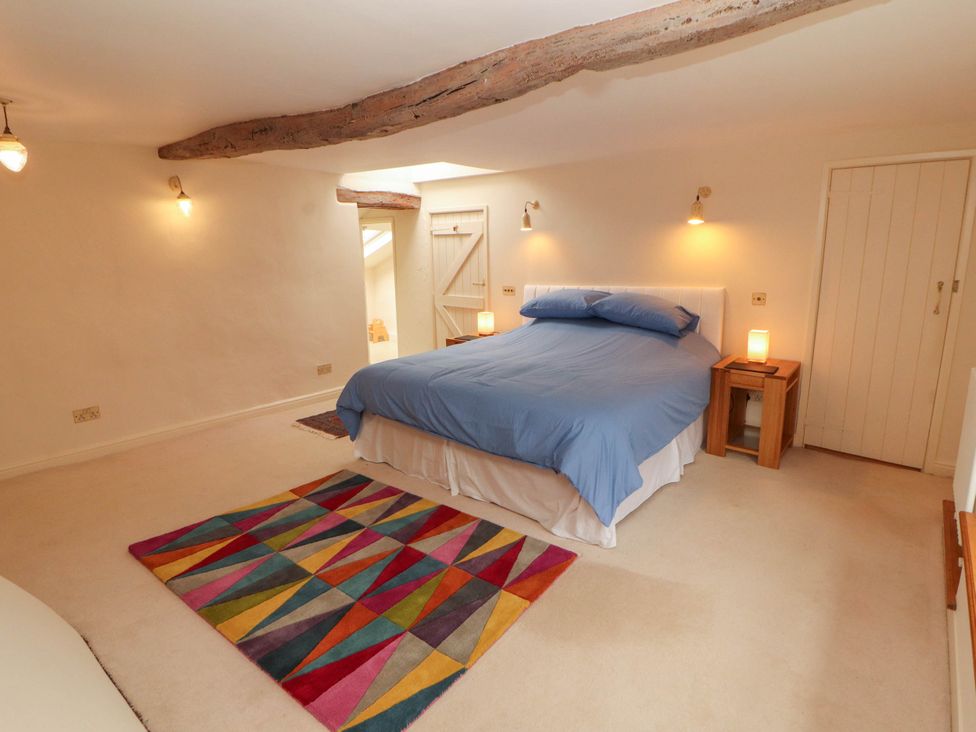 A bedroom with a bed and nightstands at Claybottom Farm near Hesket Newmarket