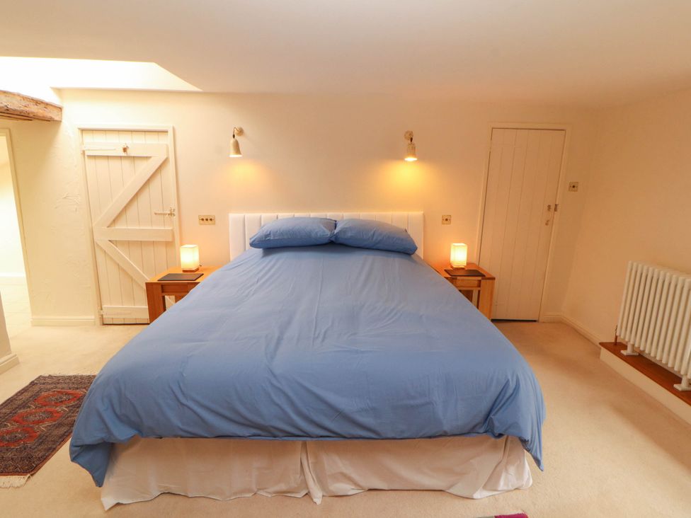 A bedroom with a bed and nightstands at Claybottom Farm near Hesket Newmarket