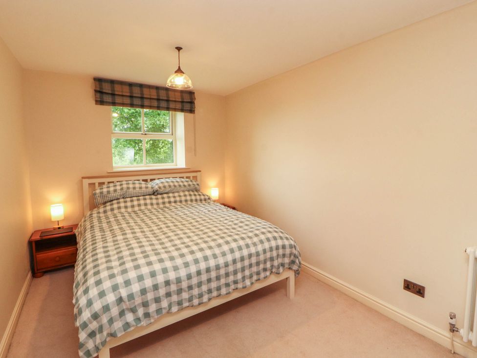 A bedroom with a bed and bedside tables at Claybottom Farm near Hesket Newmarket