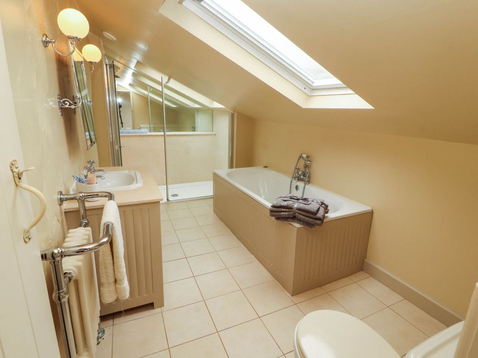 A bathroom with a bathtub, sink, and towels at Claybottom Farm near Hesket Newmarket