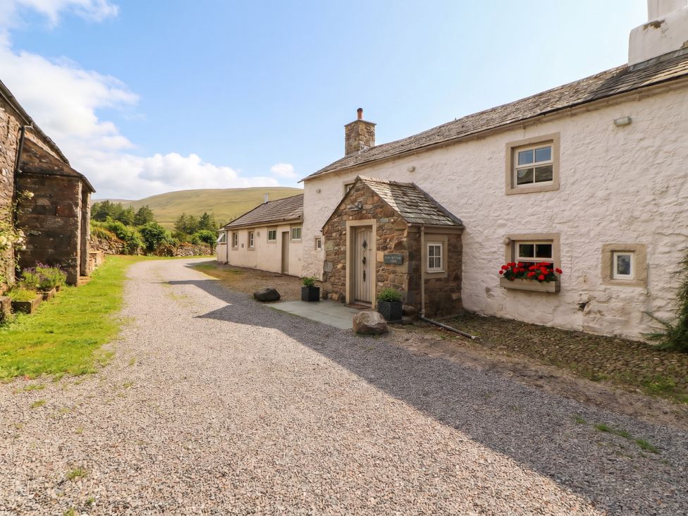 An outdoor view of a cottage with a gravel path at Claybottom Farm in Hesket Newmarket