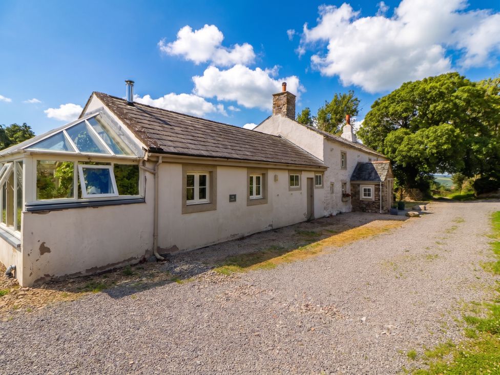 A house with a conservatory and pathway at Claybottom Farm in Hesket Newmarket