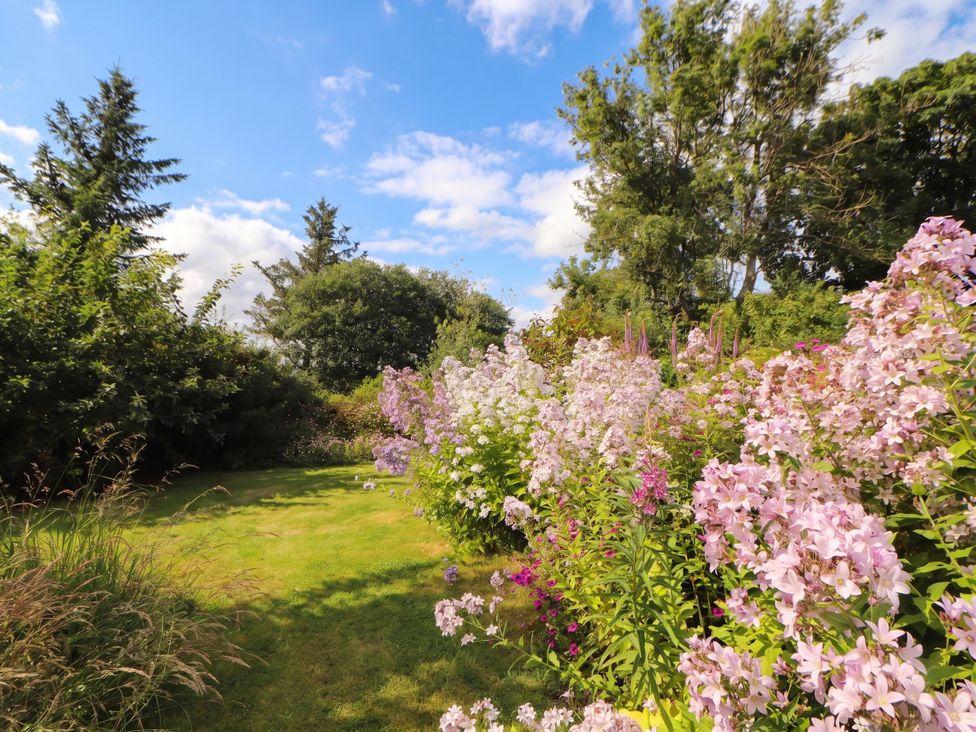 A garden with flowers and trees at Claybottom Farm in Hesket Newmarket