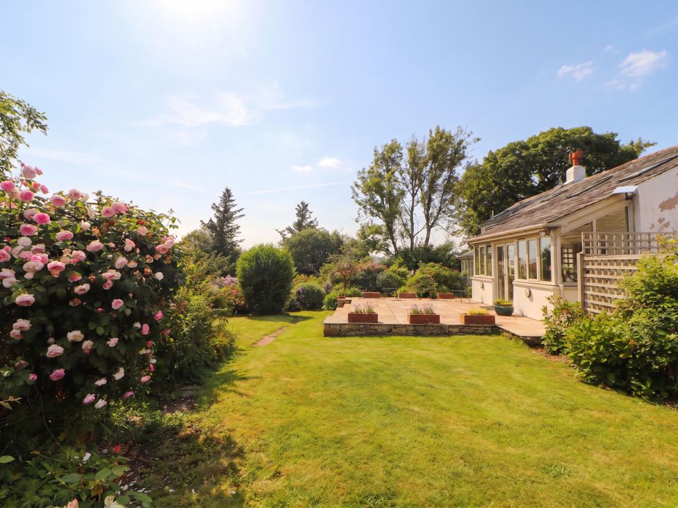 A garden with flowers and a patio at Claybottom Farm in Hesket Newmarket