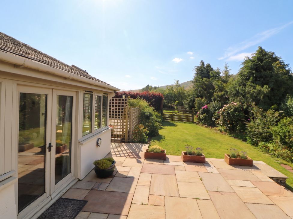 A garden with planters and glass doors at Claybottom Farm in Hesket Newmarket