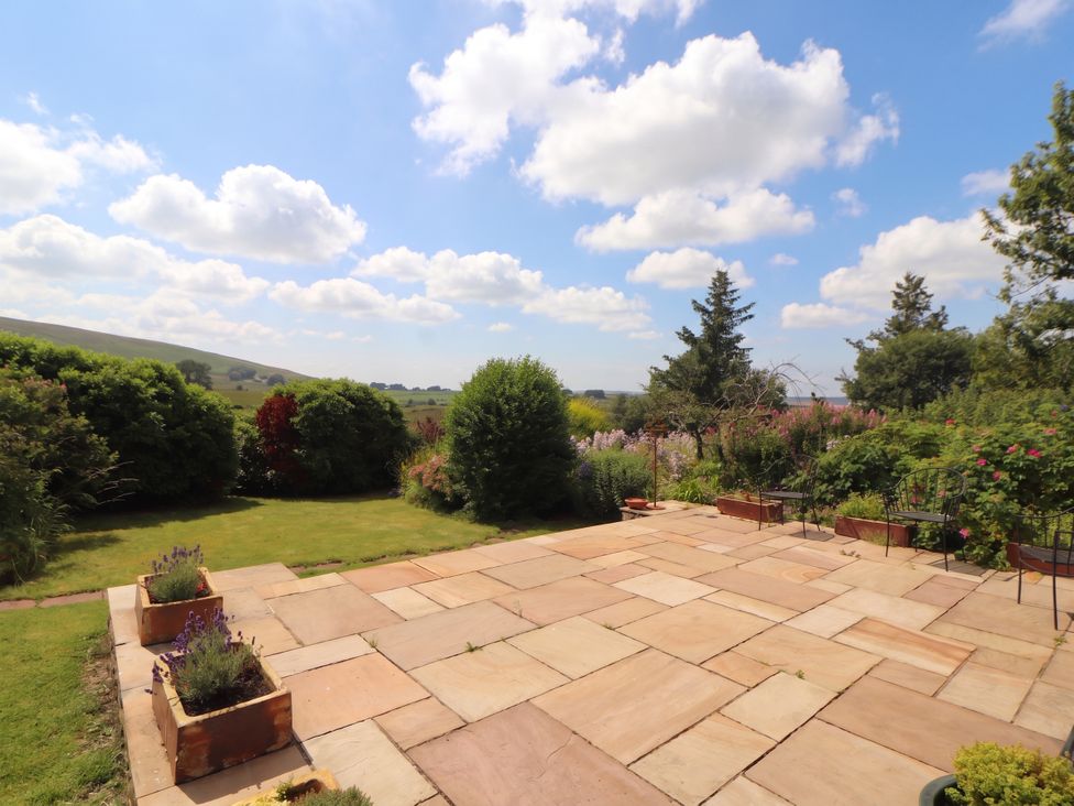 A garden with a patio and flower pots at Claybottom Farm in Hesket Newmarket