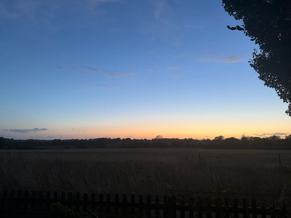 A landscape view of a field during sunset at Fables Cottage in Otley, Suffolk