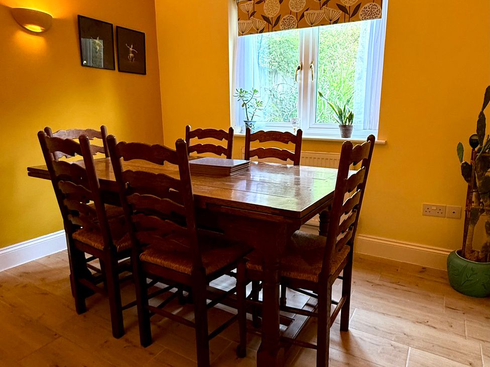 A dining room with a table and chairs at Fables Cottage in Otley, Suffolk