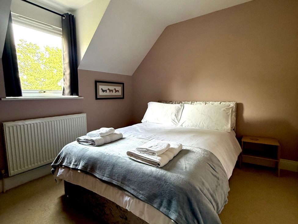 A bedroom with a bed and towels at Fables Cottage Otley, Suffolk