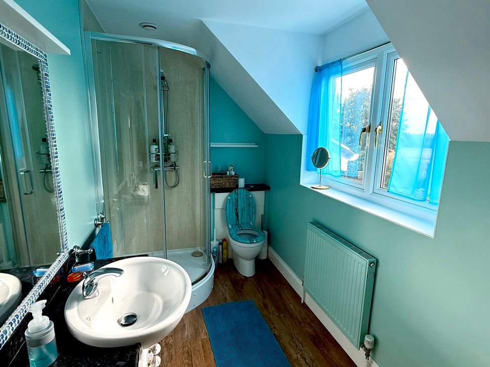 A bathroom with a shower, toilet, and sink at Fables Cottage Otley, Suffolk