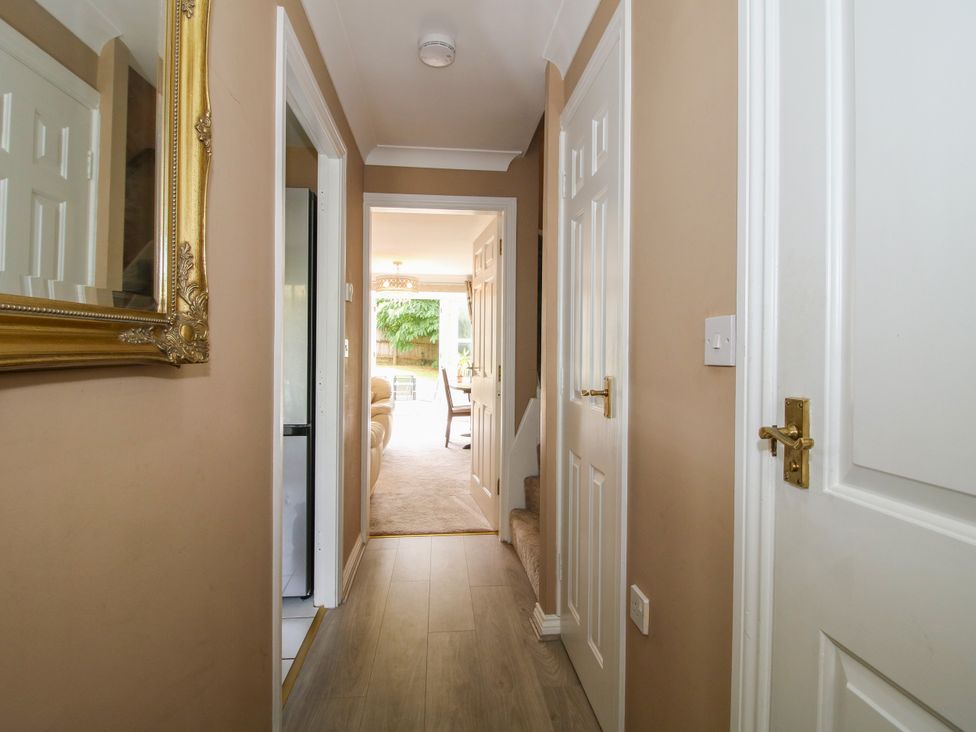 A hallway with a mirror and doors at 18 Hengrave Meadow Telford
