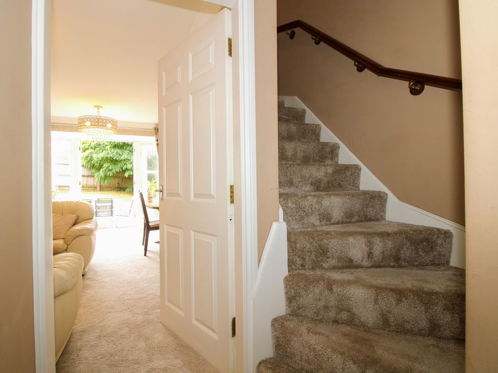 A living room with a staircase and couch at 18 Hengrave Meadow in Telford