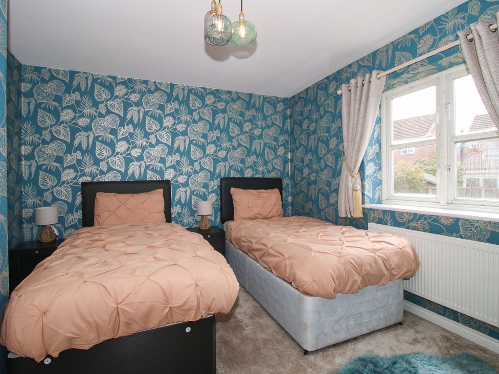 A bedroom with two single beds and a window at 18 Hengrave Meadow in Telford