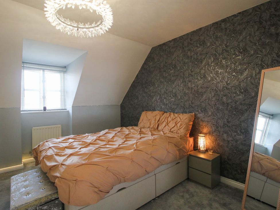 A bedroom with a bed and mirror at 18 Hengrave Meadow in Telford