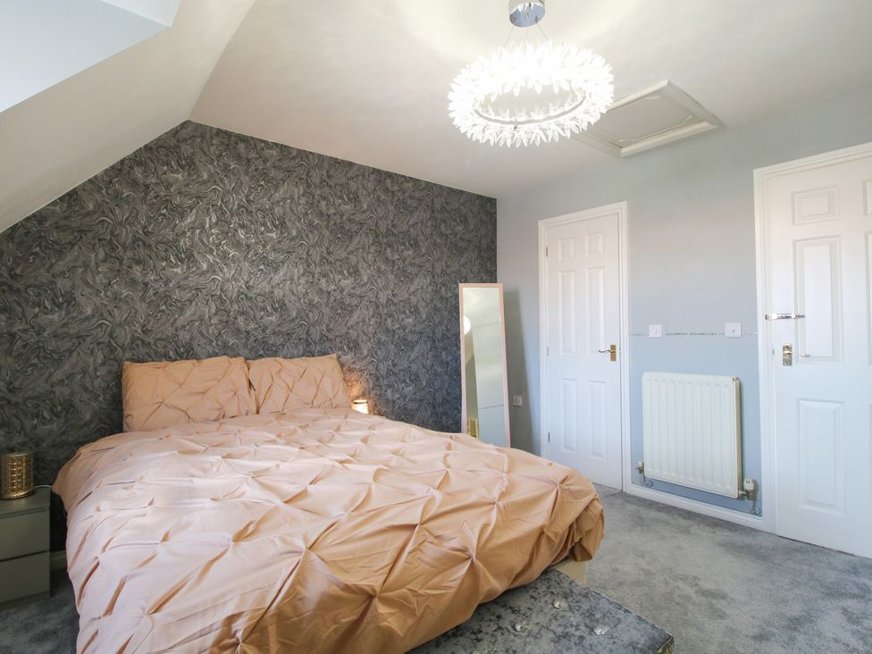 A bedroom with a bed and mirror at 18 Hengrave Meadow in Telford