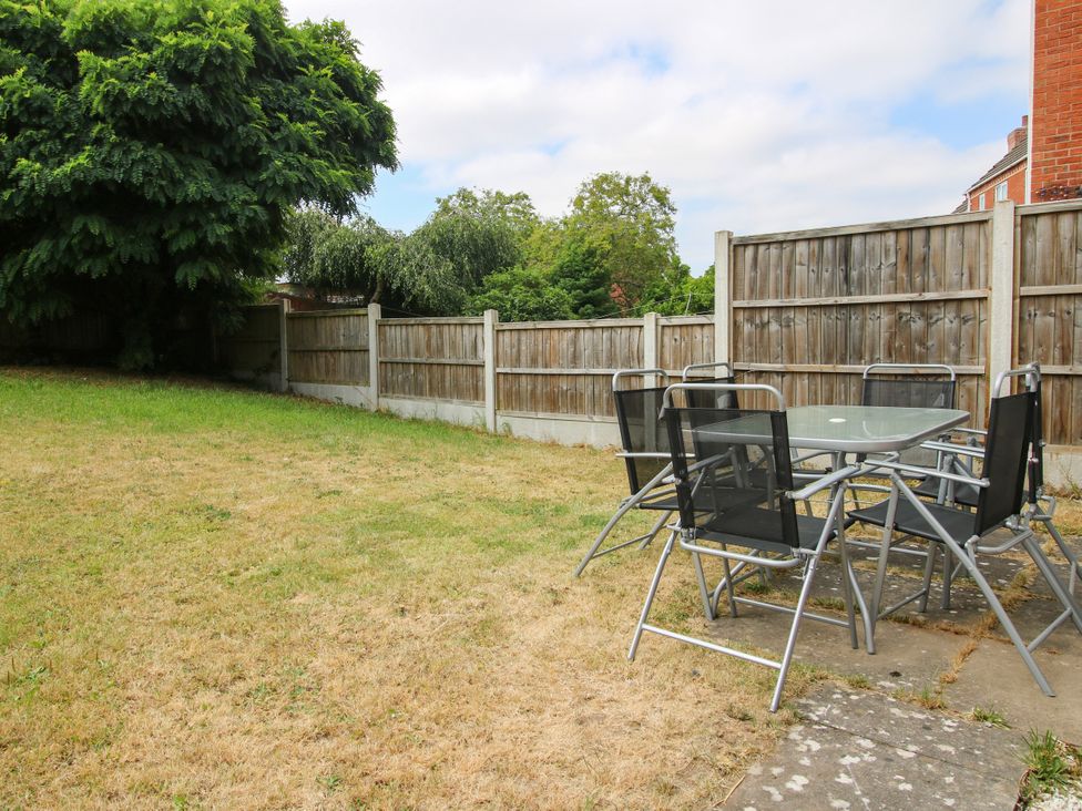 A garden with a table and chairs at 18 Hengrave Meadow in Telford
