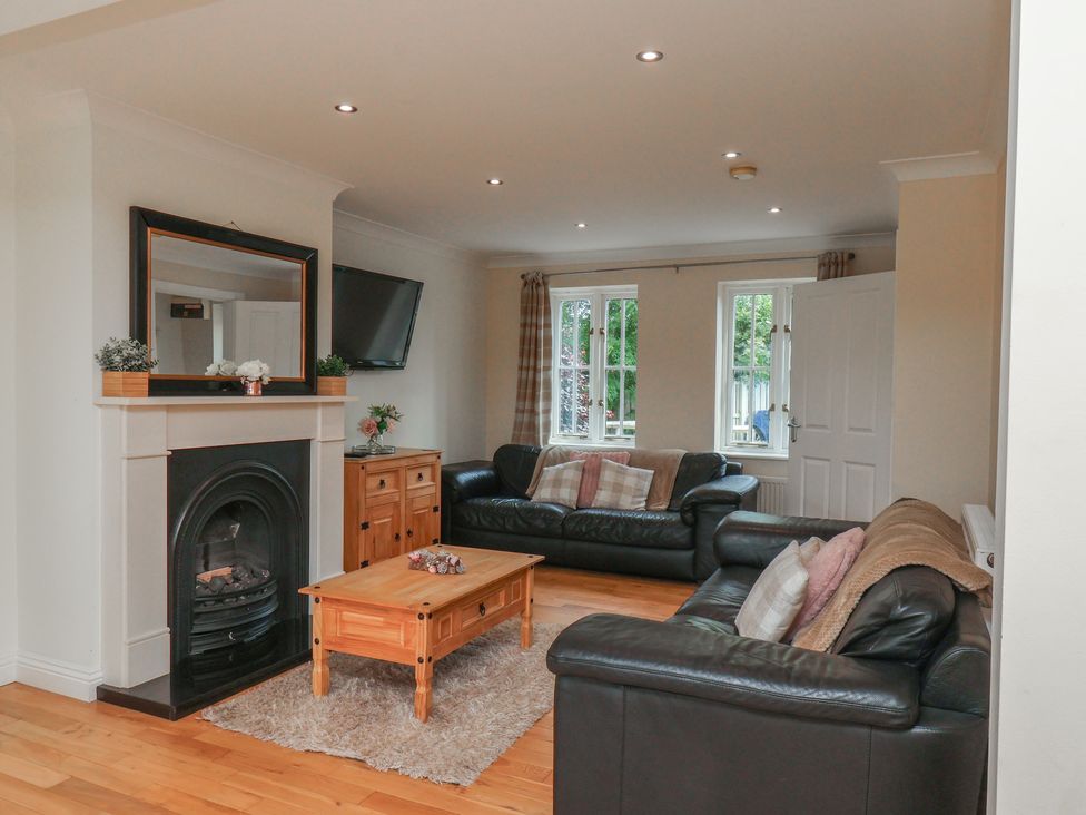 A living room with a fireplace and sofas at The Cosy Haven in Malton